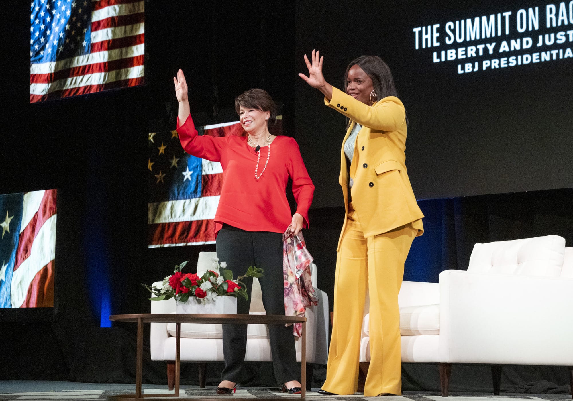 Valerie Jarrett and Brittany Packnett wave to the audience.